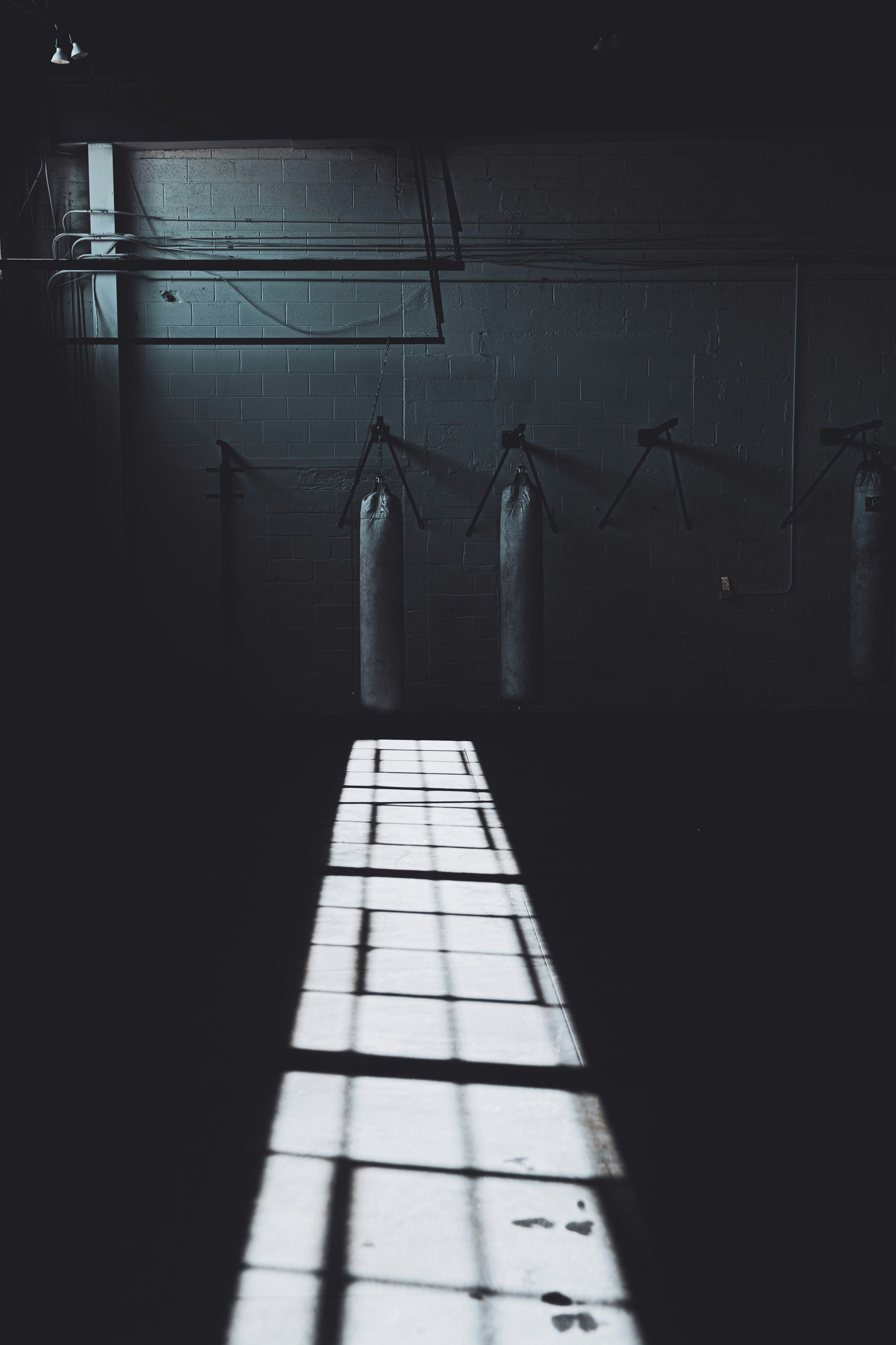 Premium industrial boxing punching bag hanging in dark gym