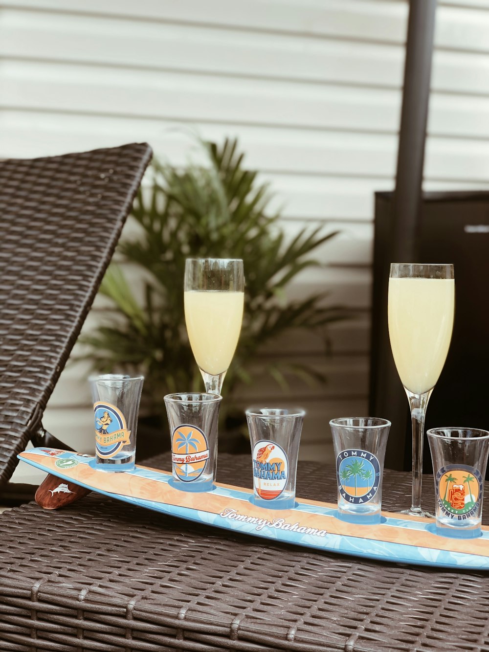 clear drinking glass with yellow liquid on blue and brown wooden table