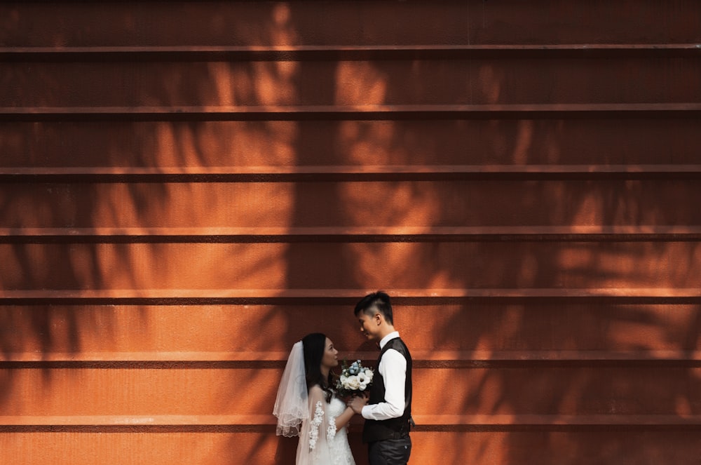 man in black suit jacket and woman in white wedding dress