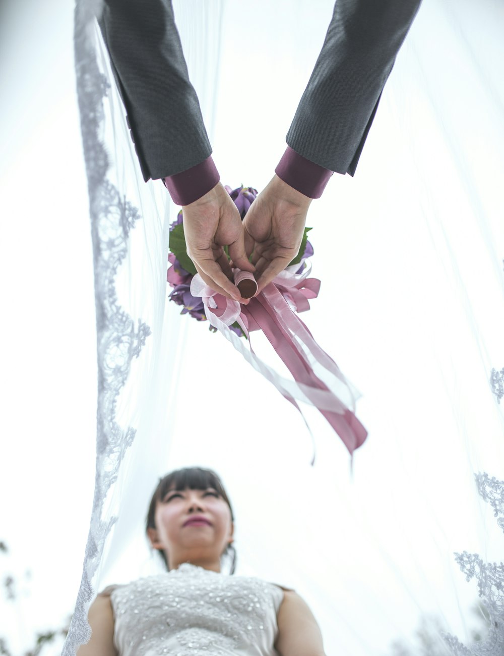 man in black pants holding girl in pink dress