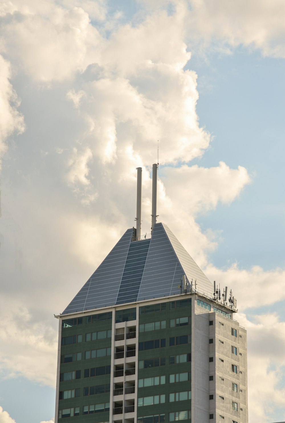 green and white concrete building under white clouds during daytime