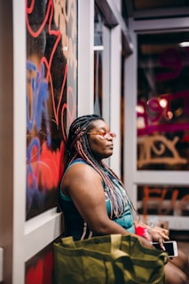 woman in black tank top and red white and blue floral skirt sitting on white wooden