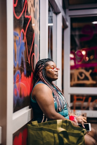 woman in black tank top and red white and blue floral skirt sitting on white wooden