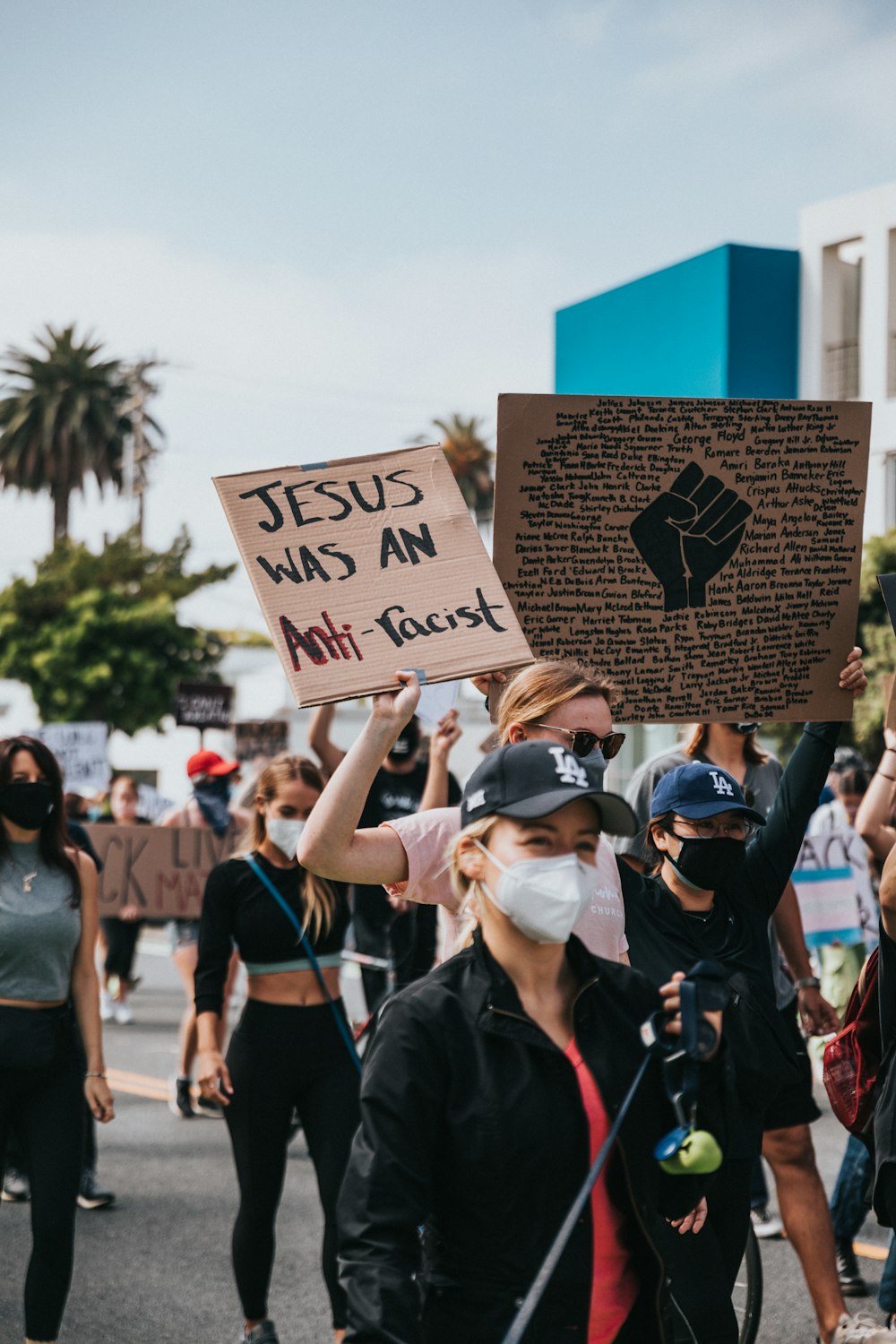 man in black jacket holding brown wooden signage