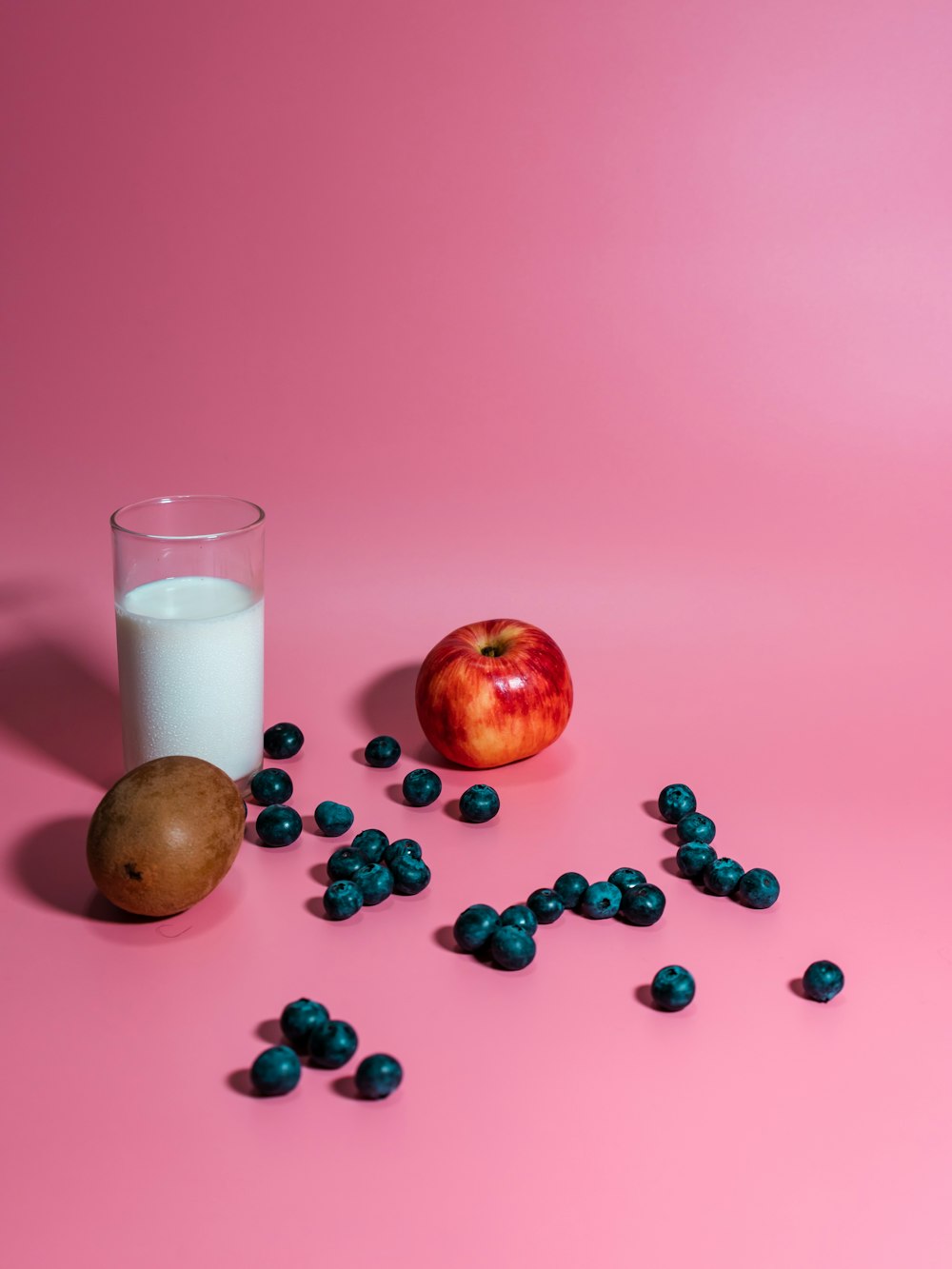 pomme rouge à côté d’un verre à boire transparent