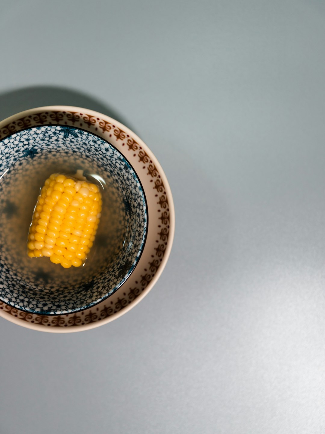 yellow corn on white and blue ceramic bowl