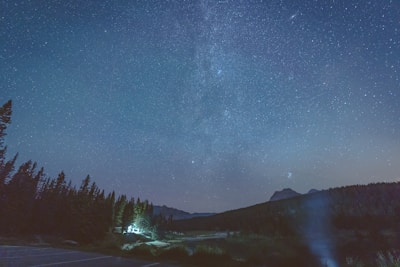 A mystical night sky with constellations softly glowing over a serene landscape.