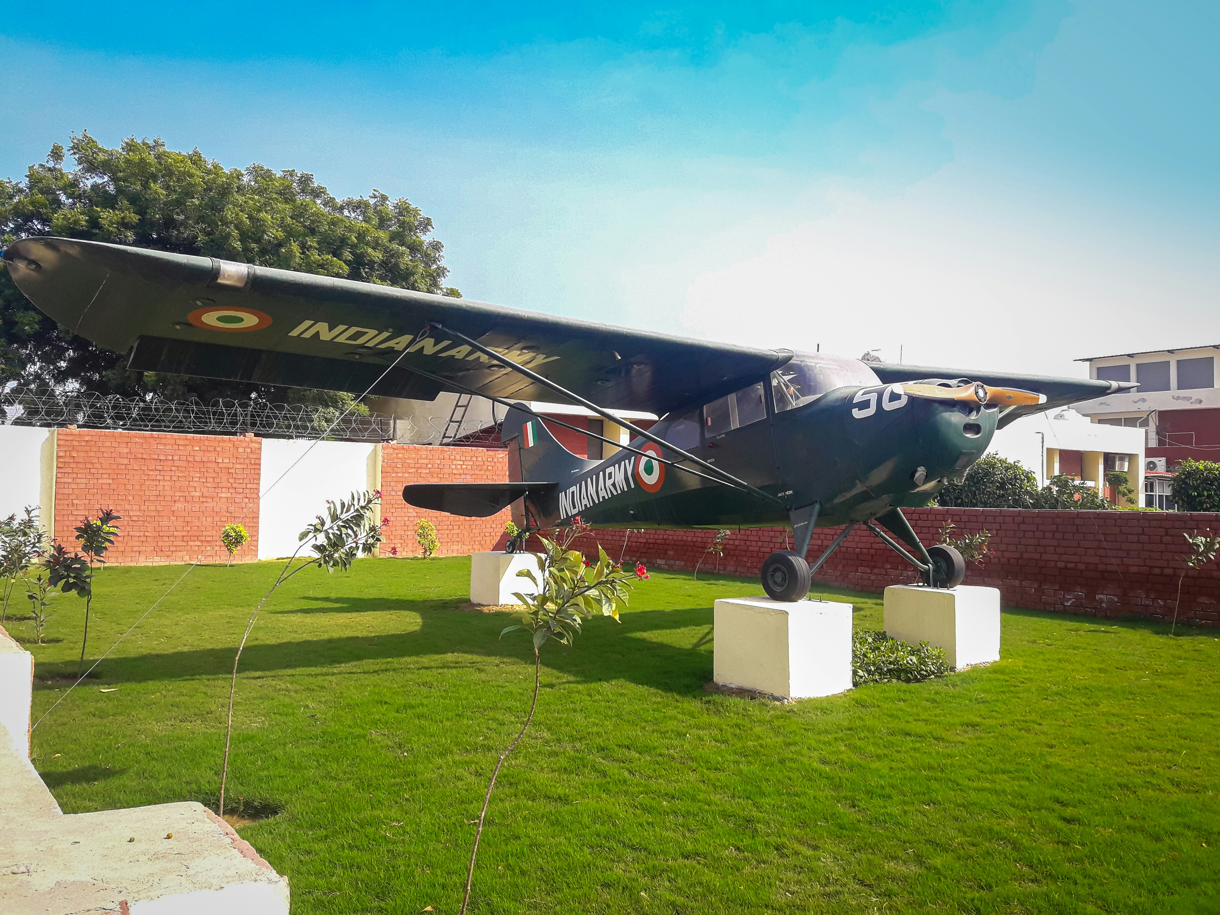 avião a jato preto e vermelho no campo de grama verde durante o dia