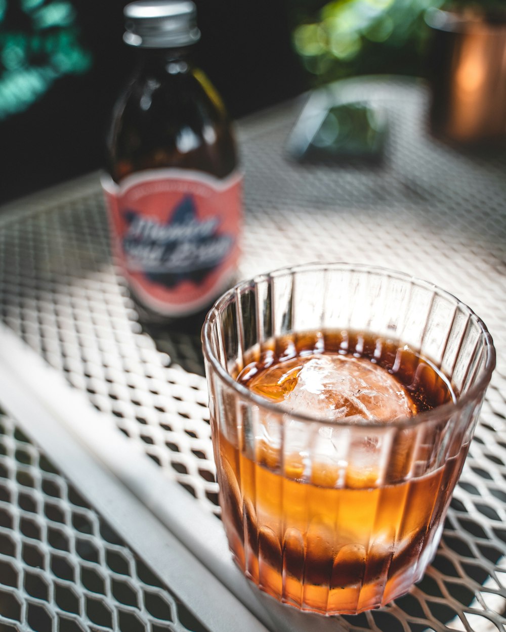 clear shot glass with brown liquid inside