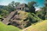 A serene view of the temazcal structure nestled among vibrant jungle foliage.