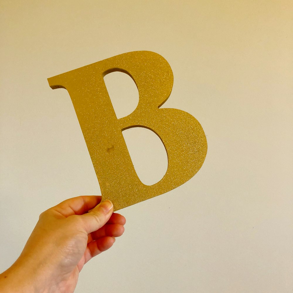 person holding orange and yellow heart shaped paper