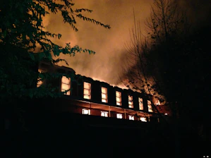 Emergency board-up service securing a fire-damaged building at night.