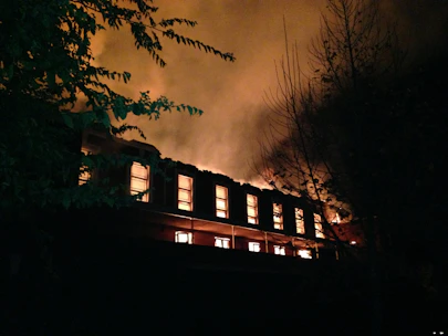 Emergency board-up service securing a fire-damaged building at night.