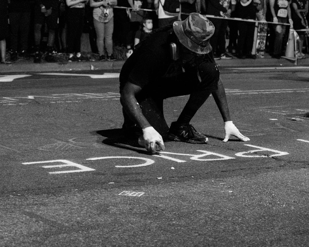 man in black t-shirt and pants playing basketball in grayscale photography