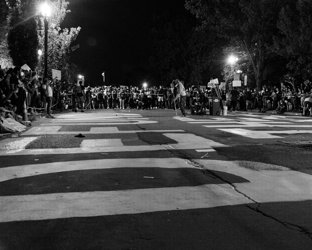 grayscale photo of people walking on pedestrian lane