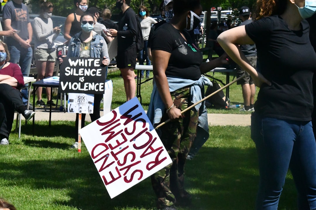 people holding white and red signage during daytime