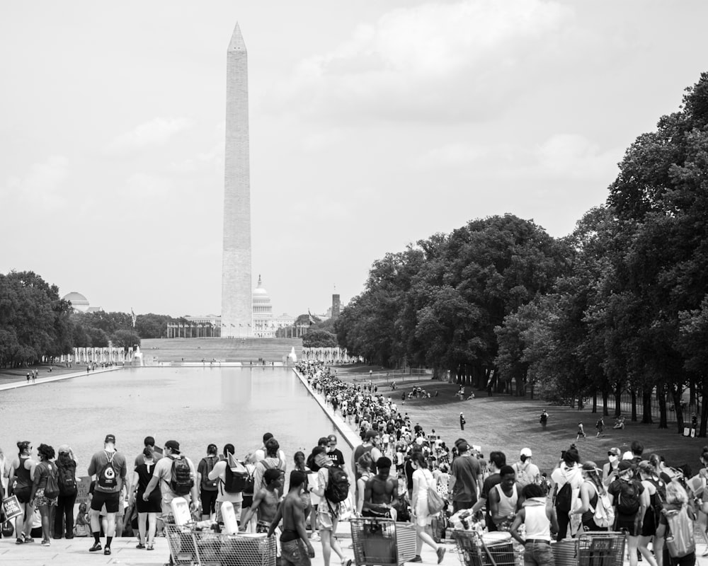 Graustufenfoto von Menschen, die im Park spazieren gehen