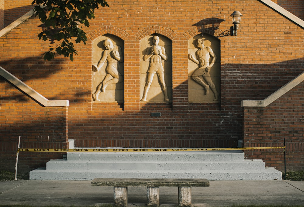 brown concrete building with two men statue