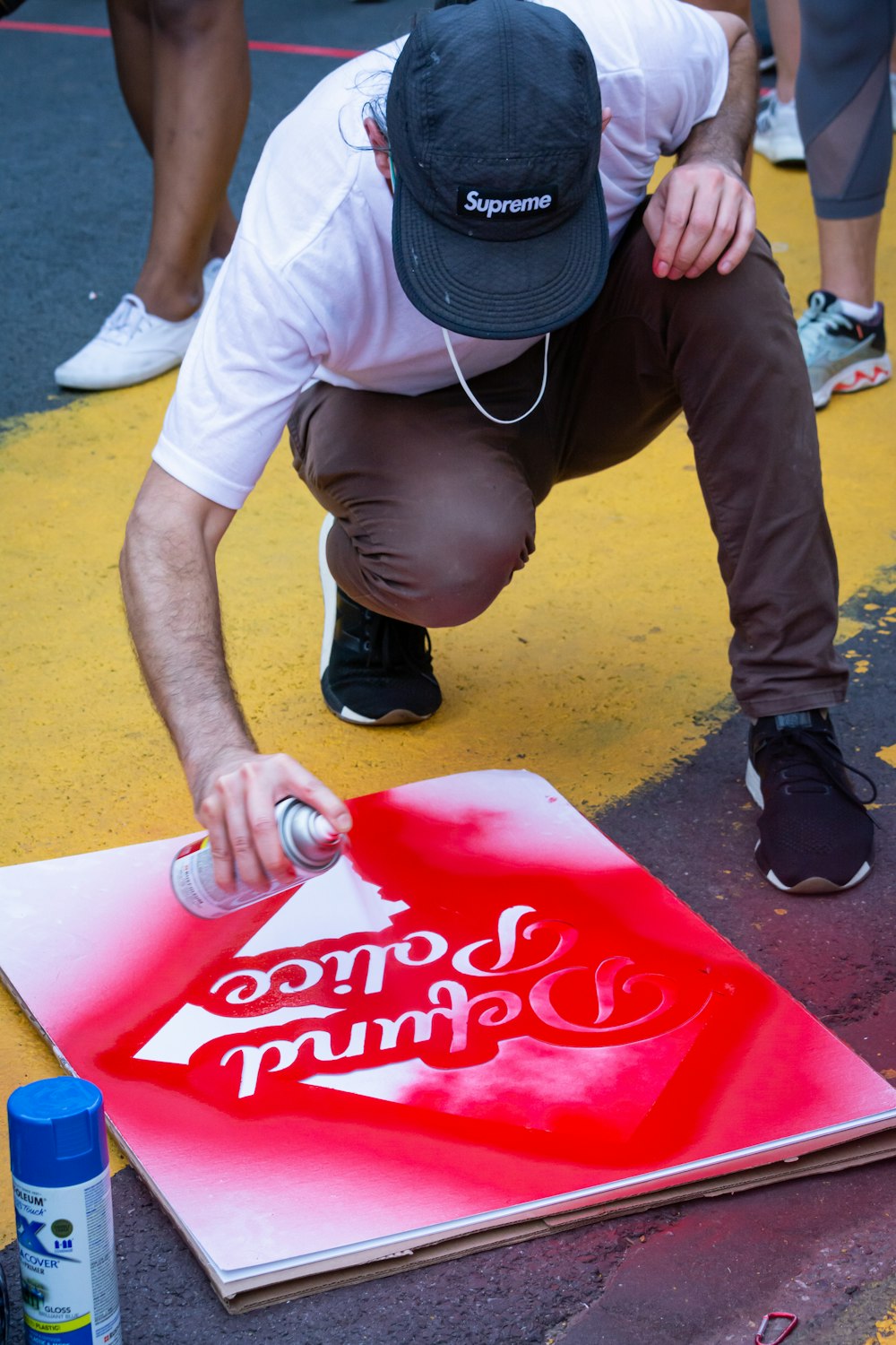 man in white t-shirt and black cap holding coca cola box