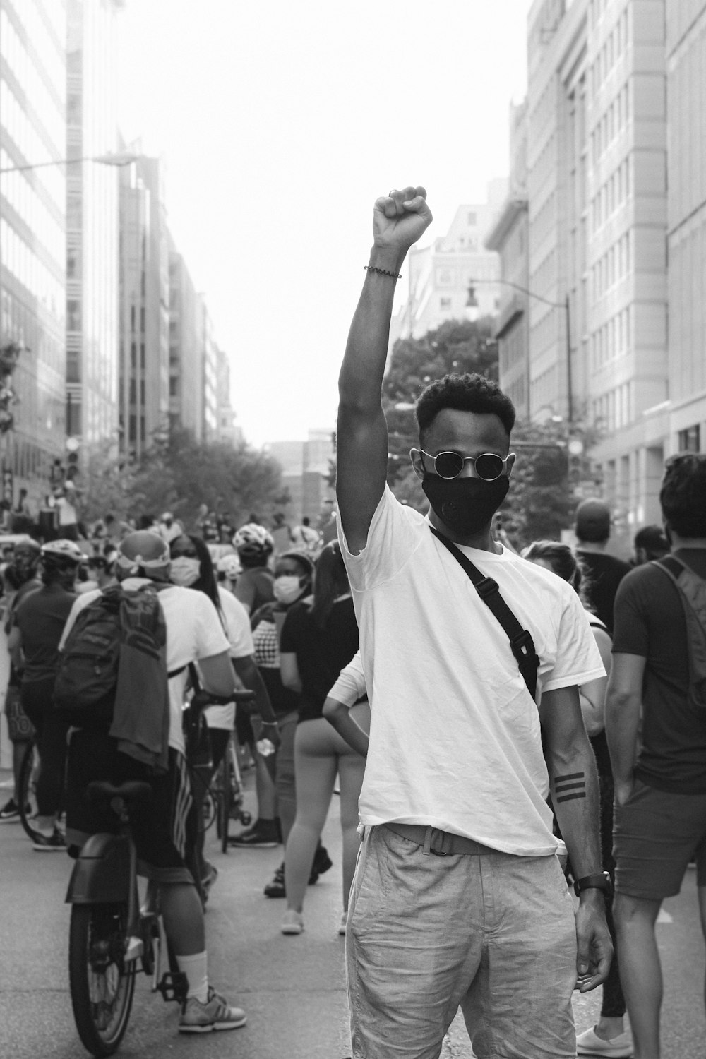 grayscale photo of man in white t-shirt raising his hands