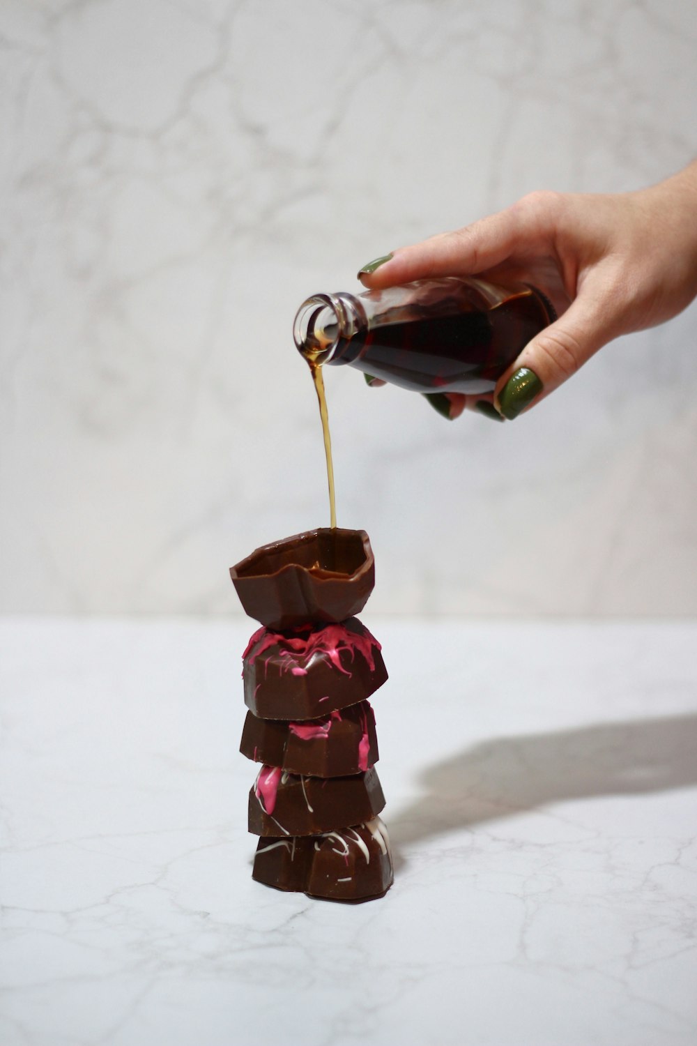 person pouring brown liquid on brown ceramic mug