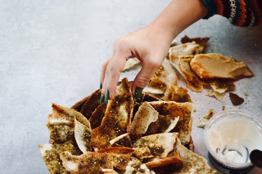 person holding brown bread on white table