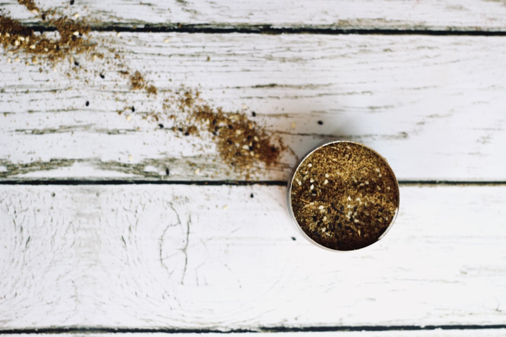 round silver coin on white wooden surface