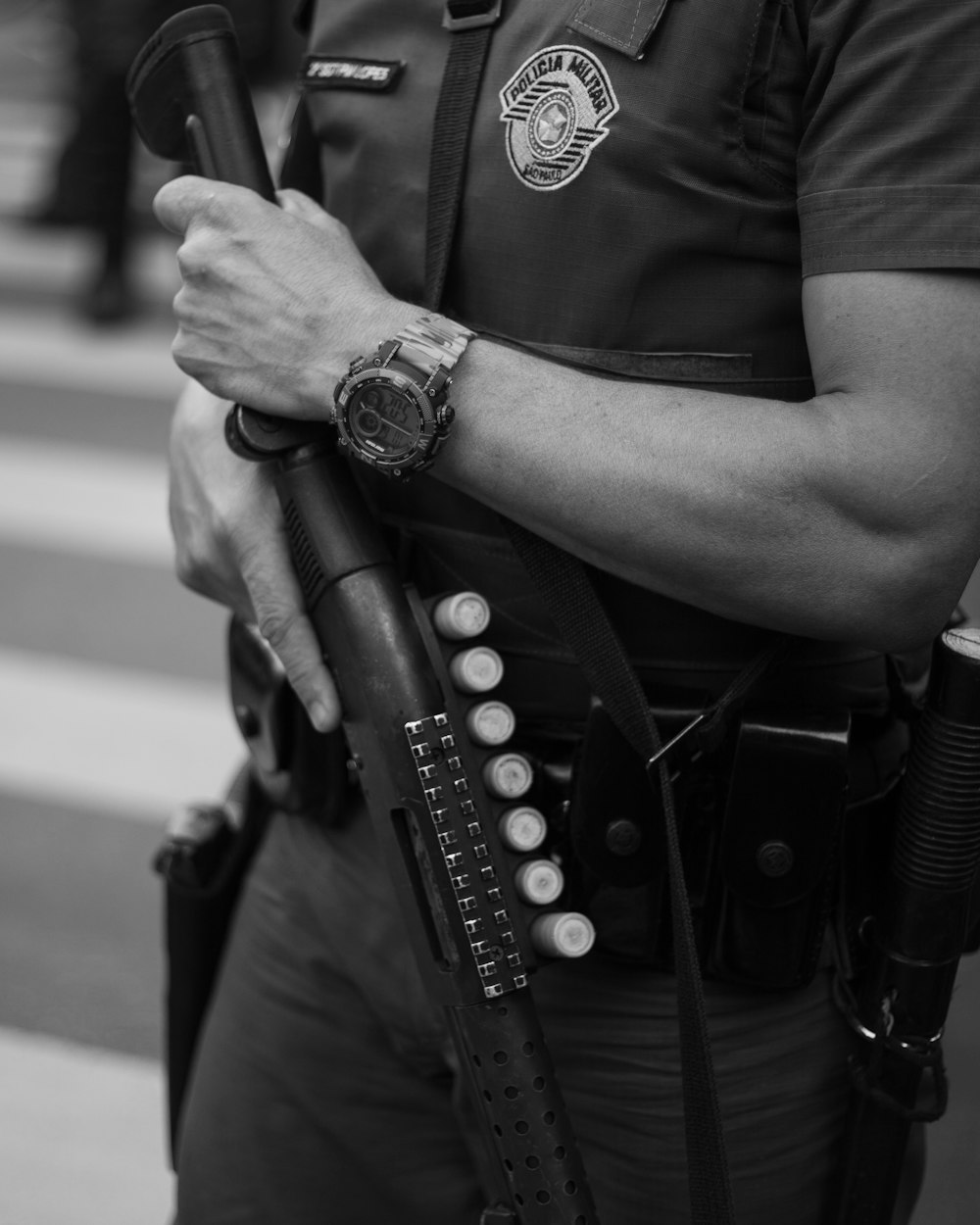 grayscale photo of man in police uniform holding rifle