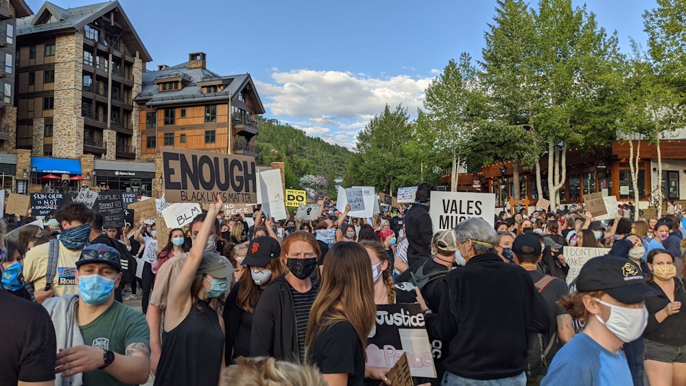 people holding white and blue signage during daytime