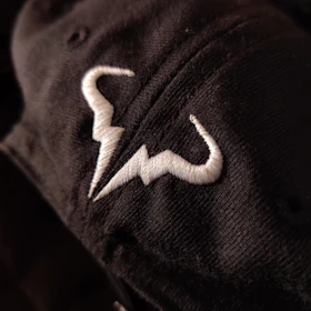 Close-up shot of premium fabric textured in black and white tones with subtle astronaut-themed embroidery detail.
