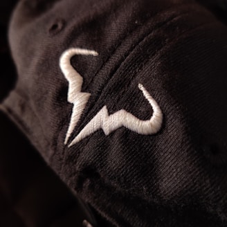 Black and white photo of embroidered fabric with detailed stitching.