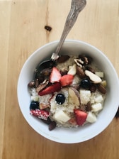 A bright bowl of oatmeal topped with fresh fruits and nuts.