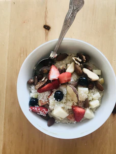A colorful bowl of fresh fruit and oats topped with nuts, perfect for a diabetic-friendly breakfast.