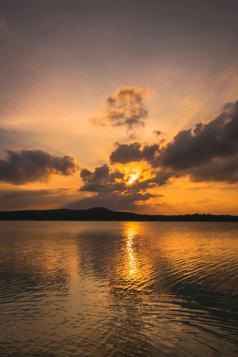 body of water under cloudy sky during sunset