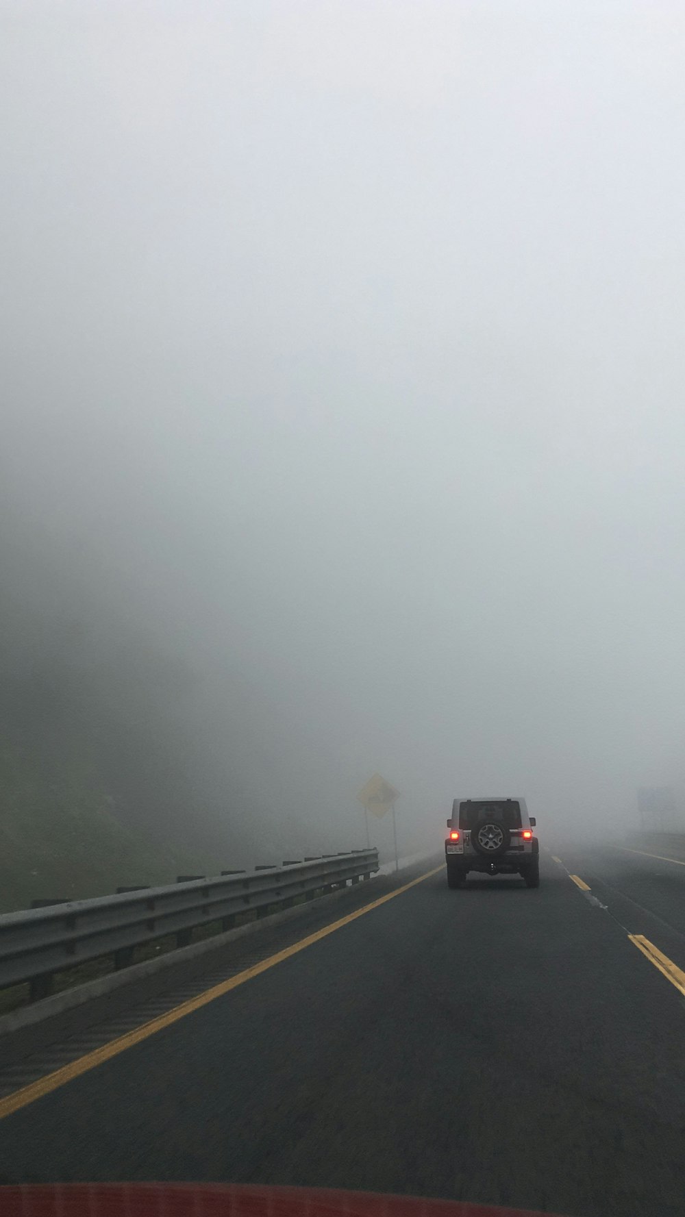 霧の天候の中で道路を走る黒いSUV