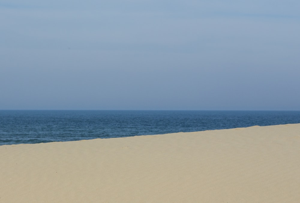 white sand near body of water during daytime