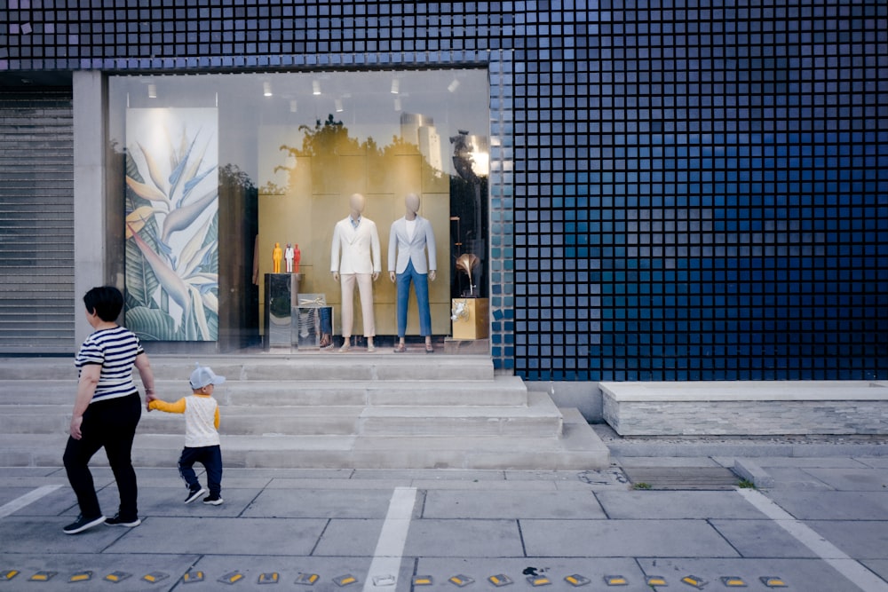 man in white thobe walking on gray concrete floor