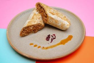 A colorful plate featuring a sliced campechano burrito with beans and rice on the side, ready to enjoy.