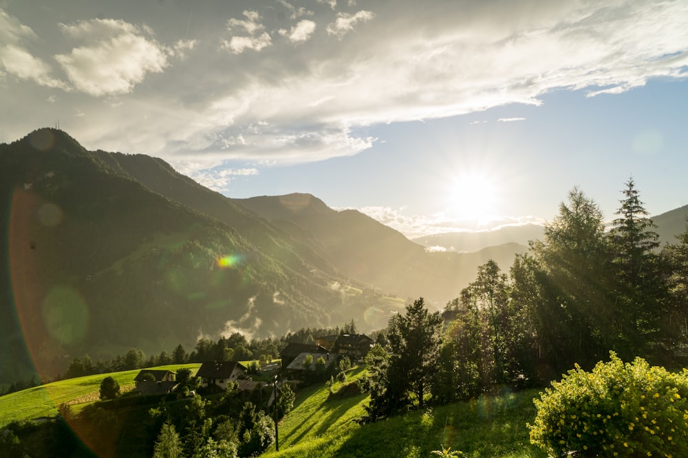 green grass field and mountains under blue sky during daytime