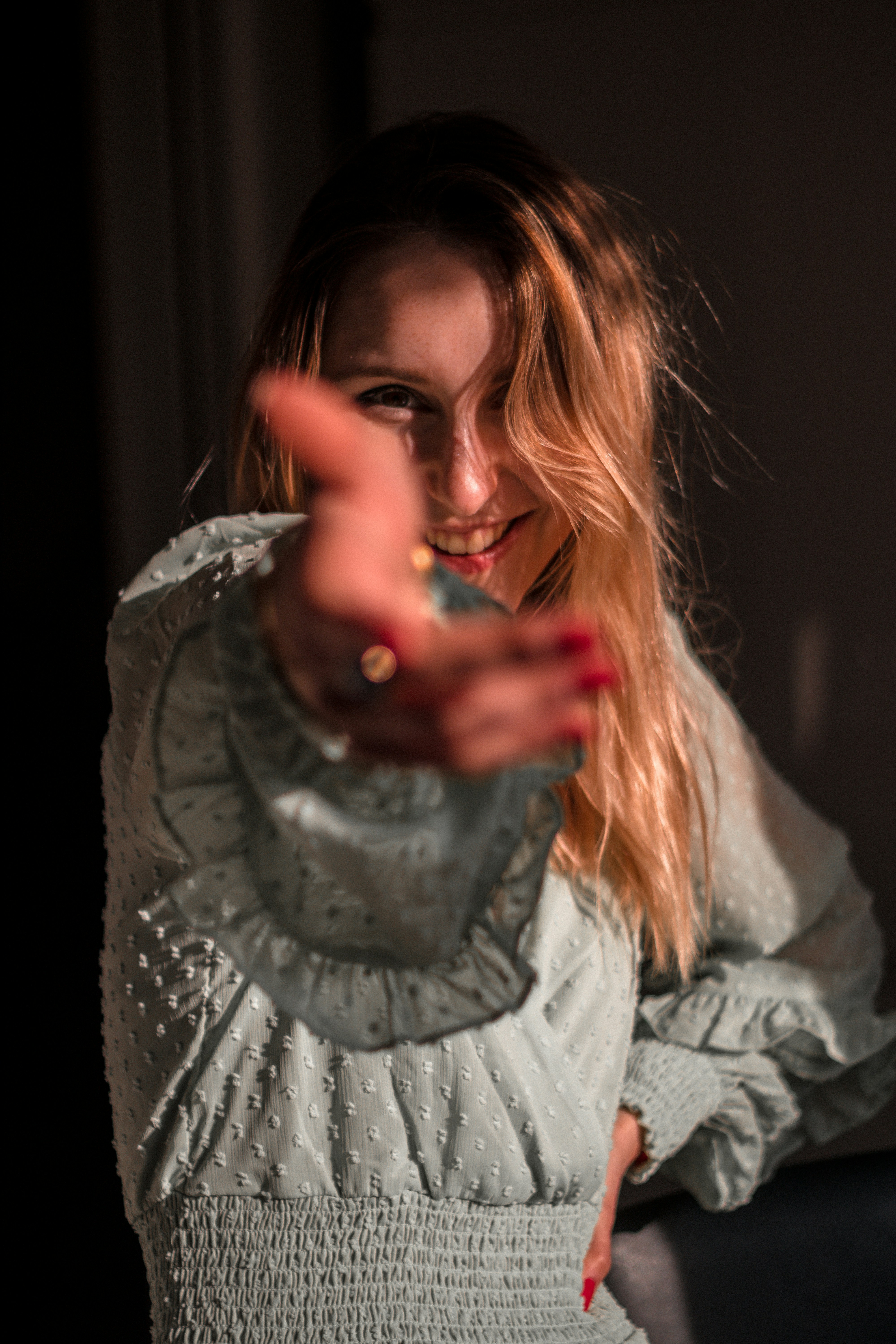woman in gray long sleeve shirt holding silver ring