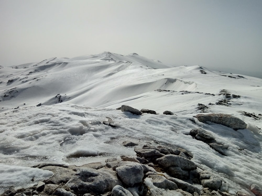 rocce nere e grigie su un campo coperto di neve bianca durante il giorno