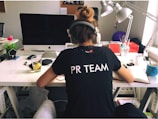 woman in black and white crew neck t-shirt sitting on black office rolling chair
