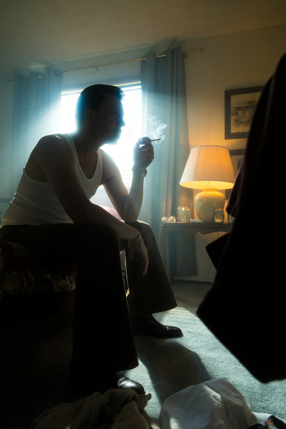 man in white tank top sitting on chair