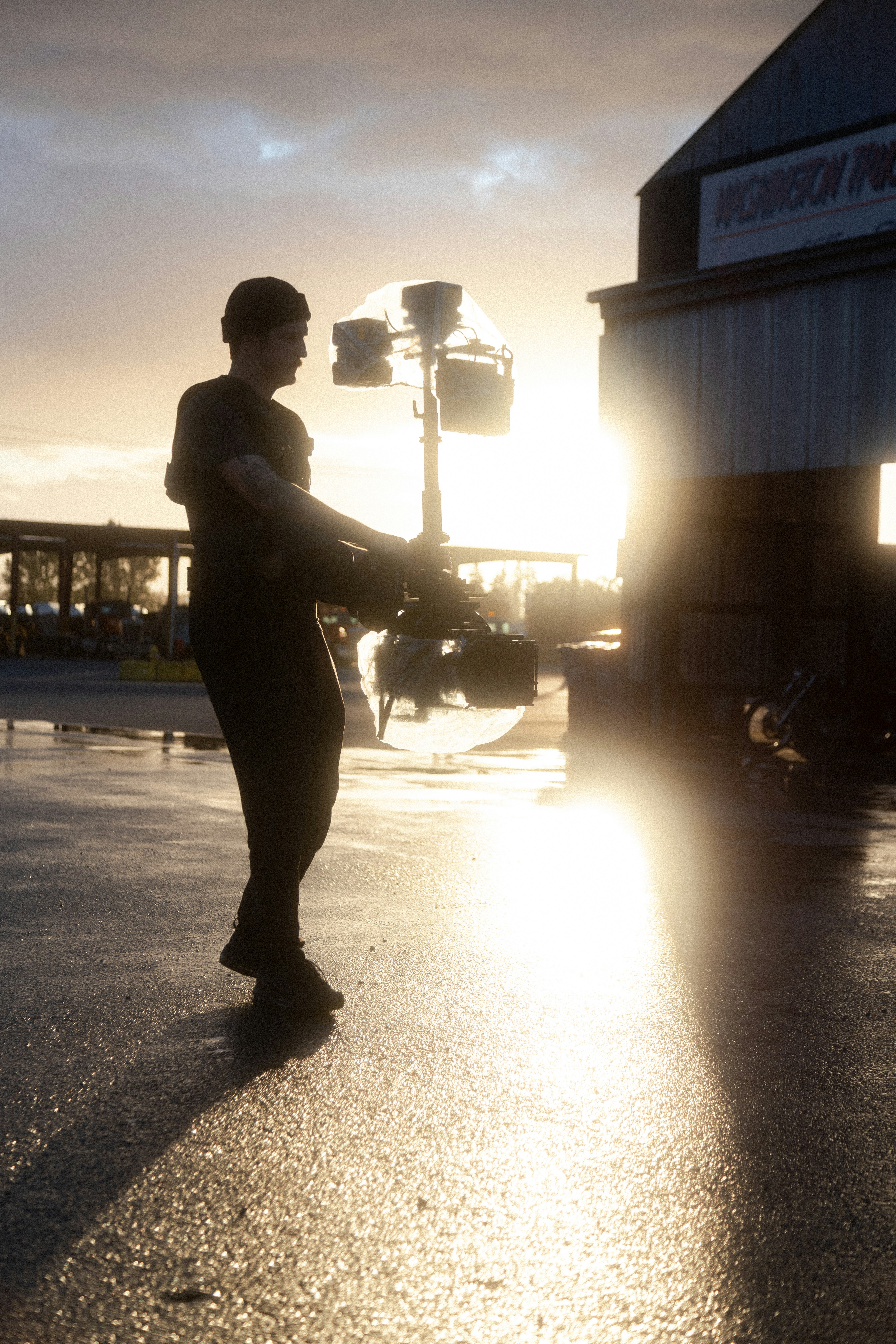 silhouette of man walking on street during sunset