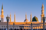 A serene mosque courtyard bathed in soft morning light with worshippers in quiet prayer.