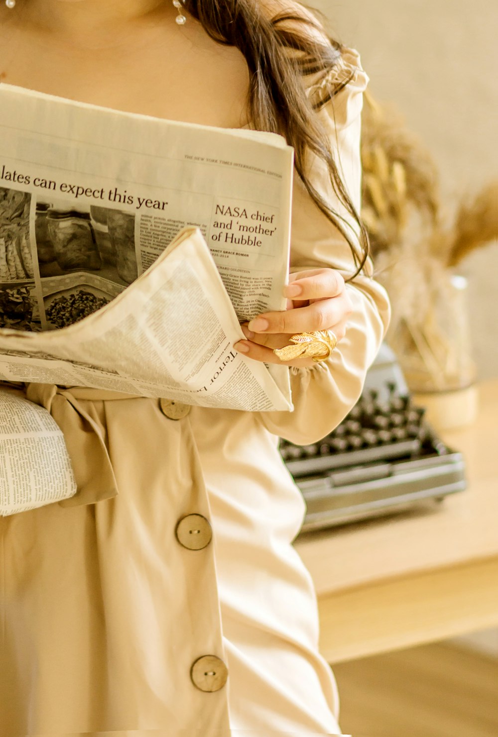 woman in beige coat holding 100 indian rupee bill