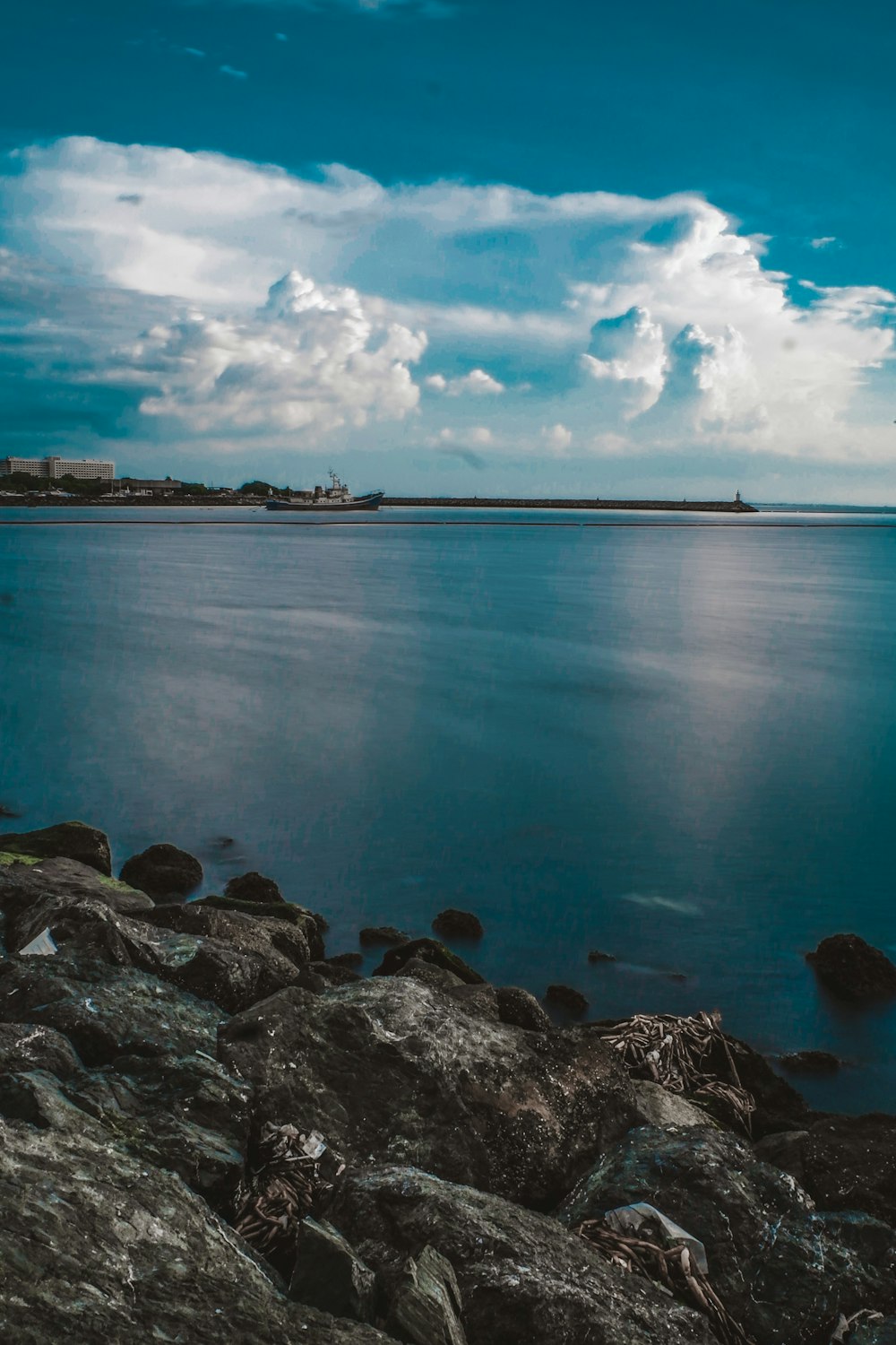 rocce grigie sulla riva del mare sotto il cielo blu durante il giorno