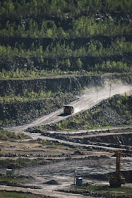 Trucks transporting silica material along dirt roads near mining and processing areas