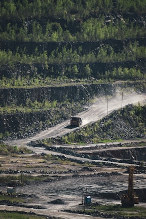 A heavy-duty mining vehicle operating smoothly on a coal site surrounded by green vegetation.
