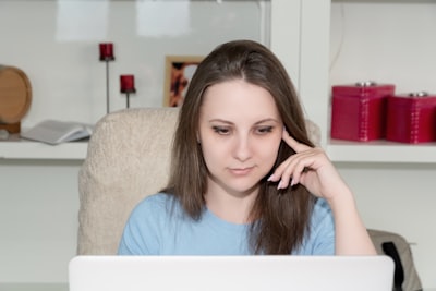 woman in blue crew neck shirt sitting on brown couch confused zoom background